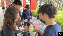 Para mahasiswa membagikan literatur untuk mendidik pemilih muda di Florida Atlantic University, di Boca Raton, Florida, 11 April 2024.