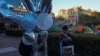 Siswa membawa balon dan mengenakan gaun untuk foto wisuda sementara siswa lainnya terus melakukan aksi protes pro- Palestina di Universitas Columbia di New York City, AS, 26 April 2024. (Foto: REUTERS/Caitlin Ochs)