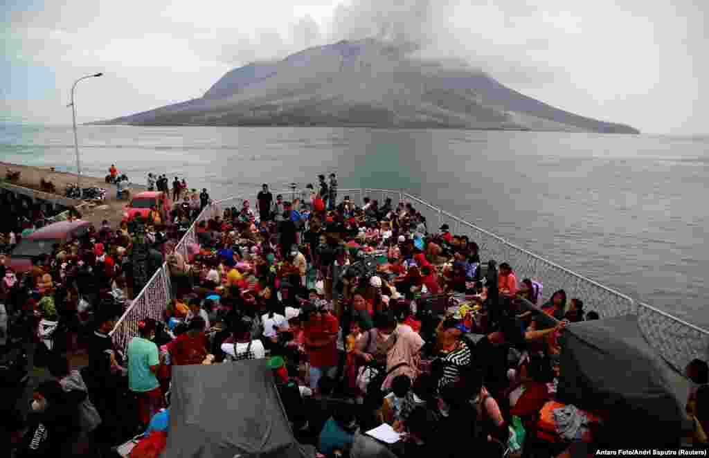 People board KRI Kakap-881 warship in the port of Tagulandang, to be evacuated to North Minahasa Regency on Sulawesi island, following the eruptions of Mount Ruang volcano in Sitaro, North Sulawesi province, Indonesia.