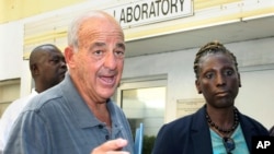 FILE - Pathologist Dr. Cyril Wecht, center, talks to the media outside the Rand Laboratory morgue at the Princess Margaret Hospital in Nassau, Bahamas, Sept. 17, 2006. Wecht, a controversial pathologist and attorney, died May 13, 2024.