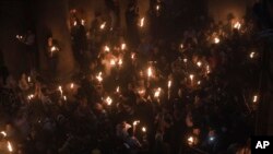 Христианские паломники с Благодатным огнем в Храме Гроба Господня. 15 апреля 2023 года.