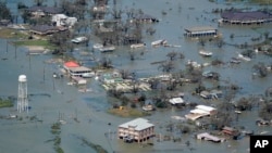 FILE - Buildings and homes are flooded in the aftermath of Hurricane Laura near Lake Charles, La., on Aug. 27, 2020. (AP Photo/David J. Phillip, File)