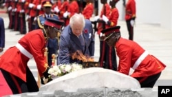 Britain's King Charles III, center, lays a wreath in honor of those who died in Kenya's quest for independence, at Uhuru Gardens in Nairobi, Oct. 31, 2023.