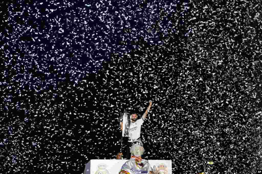 Nacho, bintang klub Real Madrid memegang trofi Liga Champions di alun-alun Cibeles selama parade trofi di ibu kota Madrid, Spanyol. (AP)&nbsp;