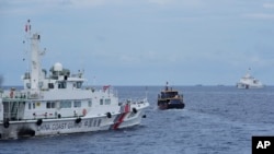 资料照：在美国海军一艘军机在天上盘旋监控下，两艘菲律宾供应船在一次危险的对峙中突破了中国海警船在托马斯第二浅滩附近的封锁。（2023年8月22日）