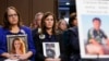FILE - People hold photos of their children during a Senate Judiciary Committee hearing on online safety for children, Feb. 14, 2023, on Capitol Hill in Washington. 