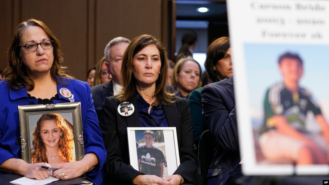 FILE - People hold photos of their children during a Senate Judiciary Committee hearing on online safety for children, Feb. 14, 2023, on Capitol Hill in Washington. 