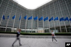 FILE - Bendera Uni Eropa berkibar tertiup angin saat pejalan kaki berjalan melewati markas besar UE di Brussels, 20 September 2023. (AP/Virginia Mayo)