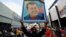 A supporter of President Nicolas Maduro holds a portrait of the late Venezuelan president, Hugo Chavez, as he takes part in a march to defend the Law against Fascism, Neofascism and Similar Expressions in Caracas on Aug. 23, 2024.