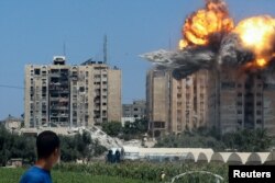 An explosion occurs following an Israeli air strike on a residential building, amid the Israel-Hamas conflict, in Nuseirat in the central Gaza Strip, July 20, 2024.