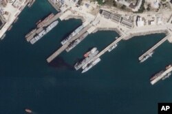 This satellite photo from Planet Labs PBC appears to show the damaged Russian landing vessel Olenegorsky Gornyak leaking oil while docked at Novorossiysk, Russia, Aug. 4, 2023.