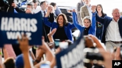 FILE - Democratic presidential nominee Vice President Kamala Harris, second gentleman Doug Emhoff (partially obscured), vice presidential nominee Tim Walz and his wife Gwen Walz greet supporters after arriving at Pittsburgh International Airport, in Pennsylvania, Aug. 18, 2024.