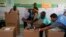 Election workers help a voter cast his ballot during general elections in Santo Domingo, Dominican Republic, May 19, 2024.