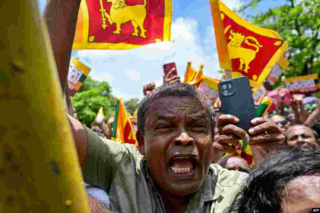 Supporters of Sri Lanka&#39;s President and United National Party presidential candidate Ranil Wickremesinghe, not pictured, cheer as he leaves the Election Commission office after filing his nomination papers for the upcoming presidential elections, in Colombo, Sri Lanka.