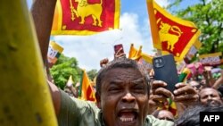 Supporters of Sri Lanka&#39;s President and United National Party presidential candidate Ranil Wickremesinghe, not pictured, cheer as he leaves the Election Commission office after filing his nomination papers for the upcoming presidential elections, in Colombo, Sri Lanka.