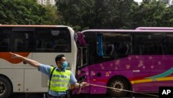 Seorang polisi memeriksa lalu lintas setelah kecelakaan di jalan raya di Hong Kong, Jumat, 24 Maret 2023. Empat bus penumpang dan sebuah truk bertabrakan di dekat terowongan jalan Hong Kong pada hari Jumat, melukai puluhan orang. (AP/Louise Delmotte)