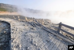 This photo released by the National Park Service shows a boardwalk damaged by a hydrothermal explosion at Biscuit Basin in Yellowstone National Park, Wyo., July 24, 2024.