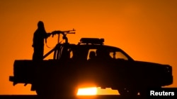 FILE - Afghan National Policemen (ANP) travel in their vehicle as the sun sets at Delaram district in Nimroz province, southern Afghanistan, Jan. 24, 2010. 