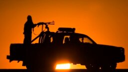 FILE - Afghan National Policemen (ANP) travel in their vehicle as the sun sets at Delaram district in Nimroz province, southern Afghanistan, Jan. 24, 2010. 