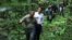 French President Emmanuel Macron walks with Gabon's Minister of Water and Forests Lee White while during his visit to the Mondah classified forest on the sidelines of the One Forest Summit in Libreville, Gabon, March 2, 2023.
