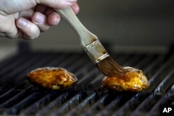 FILE - Chef Zach Tyndall prepares Good Meat's cultivated chicken at the Eat Just office in Alameda, Calif., June 14, 2023. Lab-grown meat is being fiercely opposed by some lawmakers across the U.S.