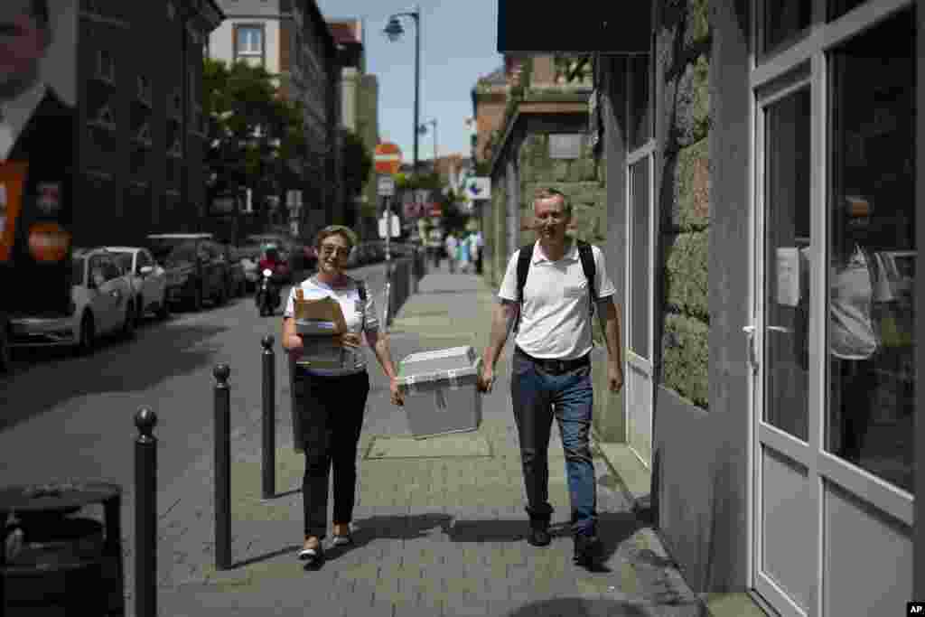 Ballot counters walk with a mobile ballot box during the European Parliamentary elections in Budapest, Hungary, June 9, 2024.