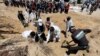 지난 21일 난민들이 이스라엘의 남부 칸 유니스의 나세르 병원 공습으로 사망한 시신을 수습하고 있다.