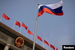 Bendera nasional Rusia berkibar di depan Aula Besar Rakyat sebelum upacara penyambutan Perdana Menteri Rusia Mikhail Mishustin di Beijing, China, 24 Mei 2023. (Foto: REUTERS/Thomas Pete)