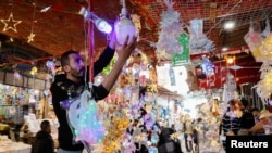 Seorang pria Palestina mengatur dekorasi untuk dijual di tokonya menjelang bulan suci Ramadan, di Kota Gaza, 18 Maret 2023. (REUTERS/Mohammed Salem)