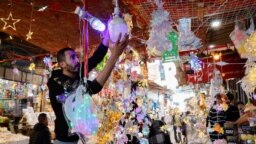 Seorang pria Palestina mengatur dekorasi untuk dijual di tokonya menjelang bulan suci Ramadan, di Kota Gaza, 18 Maret 2023. (REUTERS/Mohammed Salem)