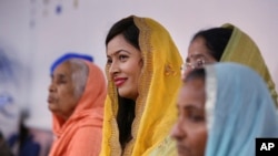 Women listen to the priest during the Shri Guru Ravidass Sabha ceremony at a temple in Fresno, California, May 7, 2023.