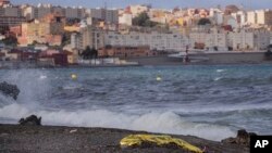FILE - Jenazah seorang pemuda ditutupi selimut darurat setelah ditemukan oleh polisi Spanyol dari perairan dekat perbatasan antara Maroko dan daerah kantong Ceuta di Afrika utara Spanyol, Kamis, 20 Mei 2021. (AP/Bernat Armangue)