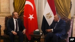 Menteri Luar Negeri Mesir Sameh Shoukry (kanan) dan Menteri Luar Negeri Turki Mevlut Cavusoglu di Istana Tahrir di Kairo, Mesir, 18 Maret 2023. Pertemuan itu adalah pertemuan pejabat tinggi pertama antara kedua negara selama lebih dari satu dekade. (Foto: Amr Nabil/AP Photo)