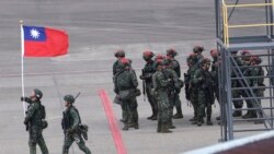 一名士兵在台灣桃園舉行的一年一度的漢光軍事演習舉著中華民國國旗。 (2023年7月26日)