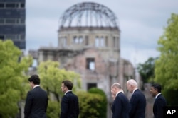 Leaders of the Group of Seven nations' meetings walk before the Atomic Bomb Dome, during a visit to the Peace Memorial Park as part of the G7 Leaders' Summit in Hiroshima, Japan, May 19, 2023.