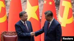 Presiden China Xi Jinping dan Presiden Vietnam To Lam berjabat tangan setelah upacara penandatanganan di Balai Besar Rakyat China di Beijing, 19 Agustus 2024. (ANDRES MARTINEZ CASARES/Pool via REUTERS)