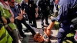 A University of Southern California protester is detained by USC Department of Public Safety officers during a pro-Palestinian occupation at the campus' Alumni Park in Los Angeles, California, April 24, 2024.
