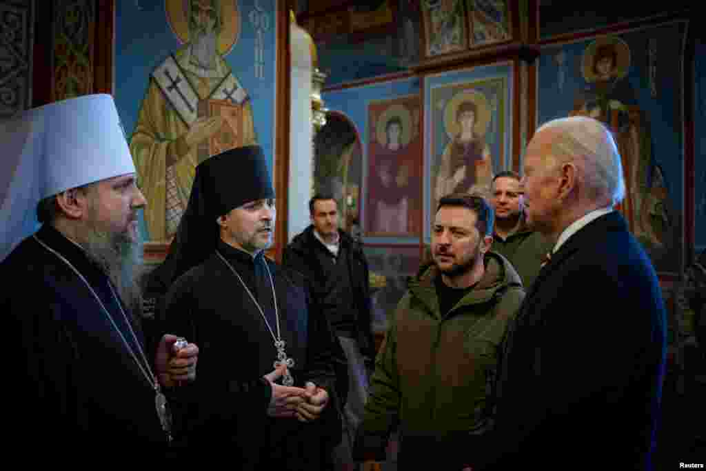 Ukraine's President Volodymyr Zelenskiy and U.S. President Joe Biden speak to Metropolitan Epifaniy I, head of the Orthodox Church of Ukraine, inside the Saint Michael's cathedral, in Kyiv, Feb. 20, 2023.