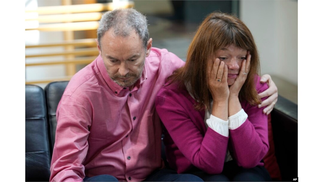 FILE - Simon Glass, left, and his wife, Sally, embrace as they talk during a news interview in the offices of the couple's lawyers in Denver, May 23, 2023.