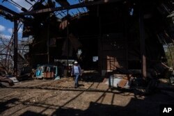 Ukrainian farmer Oleh Uskhalo walks inside a destroyed warehouse in Potomkyne, Kherson region, April 25, 2023.