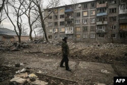 An eldery man walks among debris after a strike in the town of Chasiv Yar, in the region of Donbas, March 16, 2023, amid the Russian invasion of Ukraine.