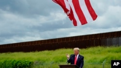 FILE - Former President Donald Trump speaks during a visit to an unfinished section of border wall with Texas Gov. Greg Abbott, in Pharr, Texas, June 30, 2021.