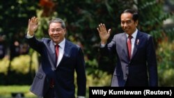 Perdana Menteri China Li Qiang dan Presiden Joko Widodo melambai kepada wartawan saat mereka berjalan di taman Istana Kepresidenan saat bertemu di Jakarta, 8 September 2023. (Foto: REUTERS/Willy Kurniawan)