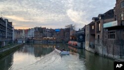 FILE - People take a boat tour through the canals in Ghent, Belgium, Dec. 22, 2019. Police in Ghent and other cities on May 4, 2023, arrested seven people suspected of plotting a terrorist attack, prosecutors say. 