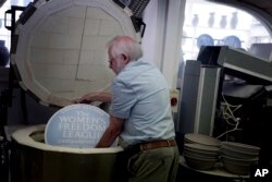 Ned Heywood loads the clay plaque into the kiln during the making of an English Heritage Blue Plaque, at Heritage Ceramics, The Workshop Gallery in Chepstow, Wales, Sept. 6, 2023.