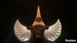 The Eiffel Tower is illuminated with wings in the foreground after the opening ceremony of the Paris 2024 Olympic Games, July 26, 2024. 