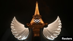 The Eiffel Tower is illuminated with wings in the foreground after the opening ceremony of the Paris 2024 Olympic Games, July 26, 2024. 