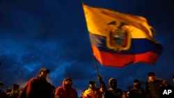 ARCHIVO - Manifestantes indígenas ondean una bandera ecuatoriana mientras caminan hacia Quito para protestar en la capital contra las políticas económicas del gobierno del presidente Guillermo Lasso en Quito, Ecuador, el 19 de junio de 2022.