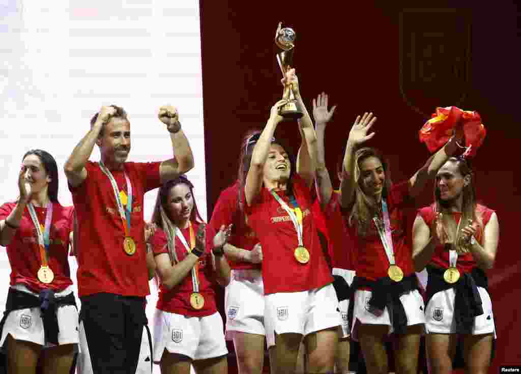 El seleccionador español, Jorge Vilda, y las jugadoras Ivana Andrés, con el trofeo, y Olga Carmona, la gran estrella de la final tras marcar el tanto de la victoria frente a Inglaterra y que supo de la muerte de su padre tras el encuentro, con una camiseta en sus manos,&nbsp; celebran el título con los miles de aficionados que se dieron cita en&nbsp;la explanada Puente del Rey, en Madrid.