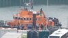 FILE - People believed to be migrants disembark a Royal National Lifeboat Institution lifeboat after being rescued from the English Channel while crossing from France, in Dover, Britain, Dec. 17, 2022. 